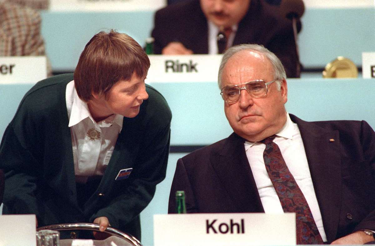 Bundesfrauenministerin Angela Merkel beugt sich am 16.12.1991 während des CDU-Parteitags in Dresden zu ihrem Mentor, Bundeskanzler Helmut Kohl, herab.