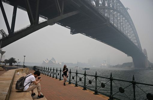Die Wahrzeichen von Sydney, das Opernhaus und die Harbour Bridge, sind im Dunst kaum mehr zu erkennen. Foto: AFP/PETER PARKS