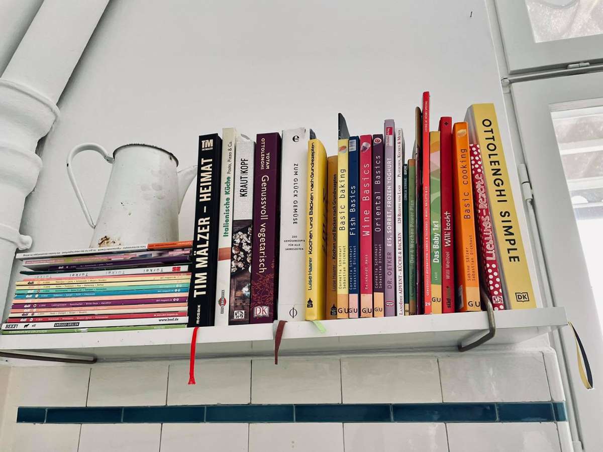Außerdem treffen in der Küche viele Kochbücher, hübsch drapiert mit einem alten Krug...