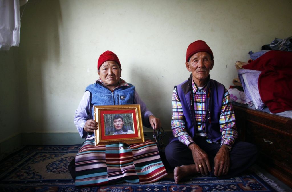 Nimdige Sherpa und ihre Ehemann Ankchu Sherpa zeigen ein Porträt ihres Sohnes Ang Kaji Sherpa, der am 18. April 2014 von einer Lawine am Khumbu-Gletscher getötet wurde.