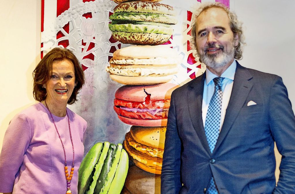 Holde Klis mit Südwestbank-Chef Wolfgang Kuhn vor ihrem Bild der französischen Macarons. Die Künstlerin malt die kleinen, kunterbunten Köstlichkeiten groß und verführerisch.