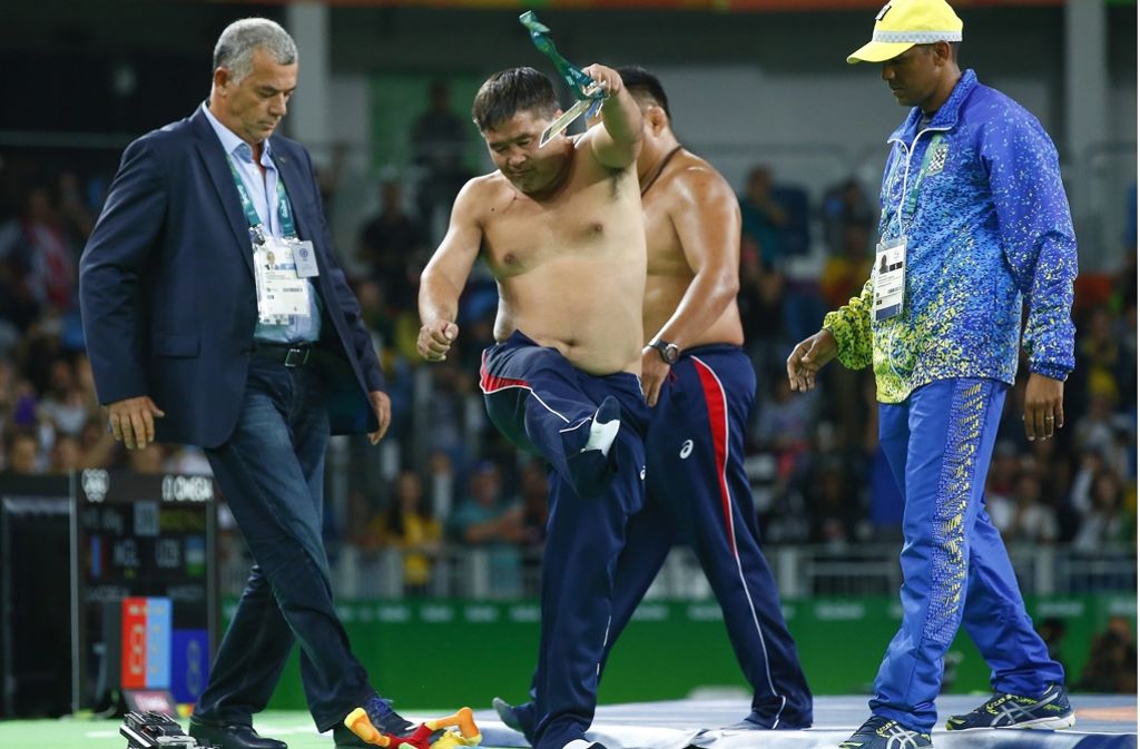 Nackter Protest: Der mongolische Ringer-Trainer ist unzufrieden mit der Wertung seines Schützlings und wirft wutentbrannt Schuhe und Kleidung von sich.