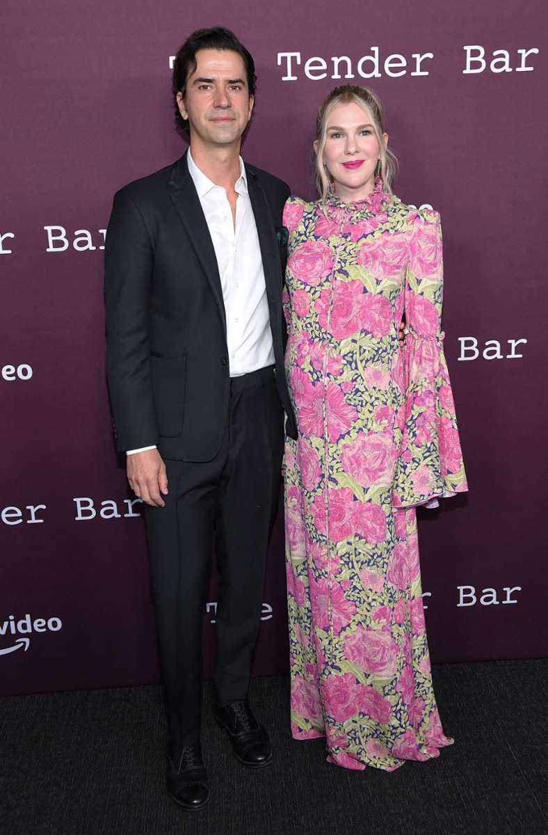Ebenfalls ein Kleid mit Rosen-Print trägt Schauspielerin Lily Rabe. Sie posiert neben Schauspieler Hamish Linklater.