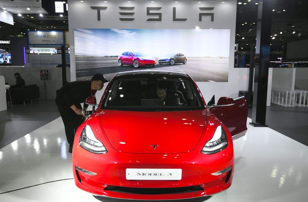 Fachbesucher schauen sich das Tesla Model 3 genauer an.