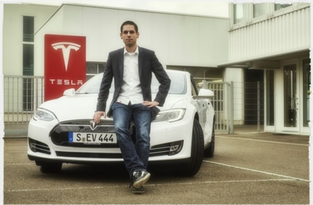 Der Store Manager Oliver von Radowitz mit einem Tesla Model S