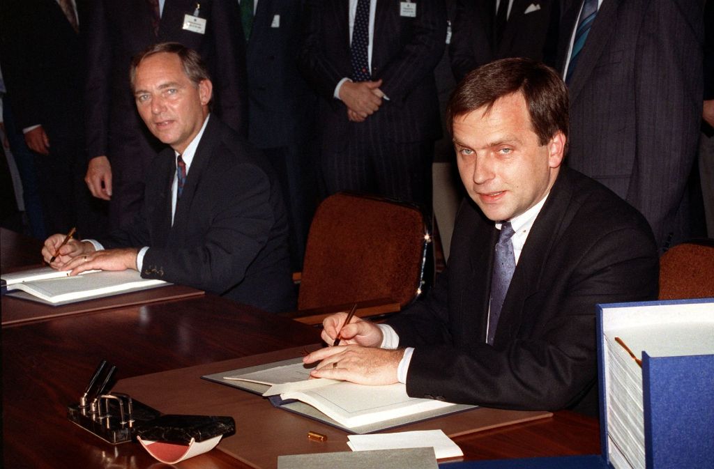 Der damalige Bundesinnenminister (links) und DDR-Staatssekretär Günther Krause bei der Unterzeichnung der Urkunden über den Beitritt der DDR zur Bundesrepublik am 3. Oktober 1990.