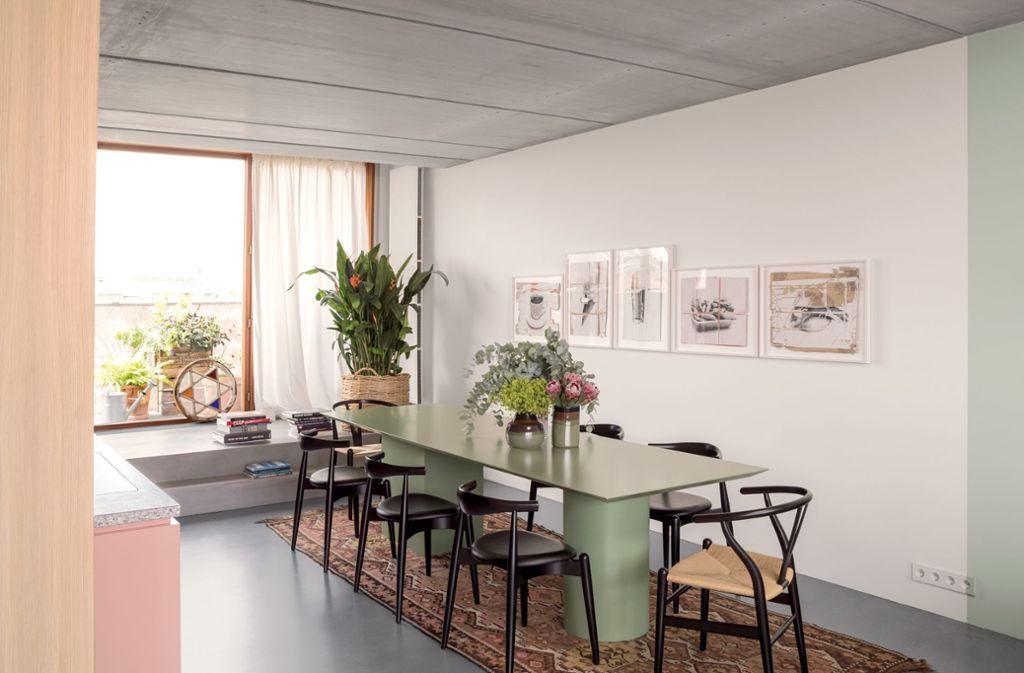 Blick in den Küchen- und Essbereich. Die Architektin Ester Bruzkus kontrastiert dezent Rosé- und Grüntöne mit Holz und Beton in ihrem preisgekrönten 80-Quadratmeter-Apartment in Berlin.