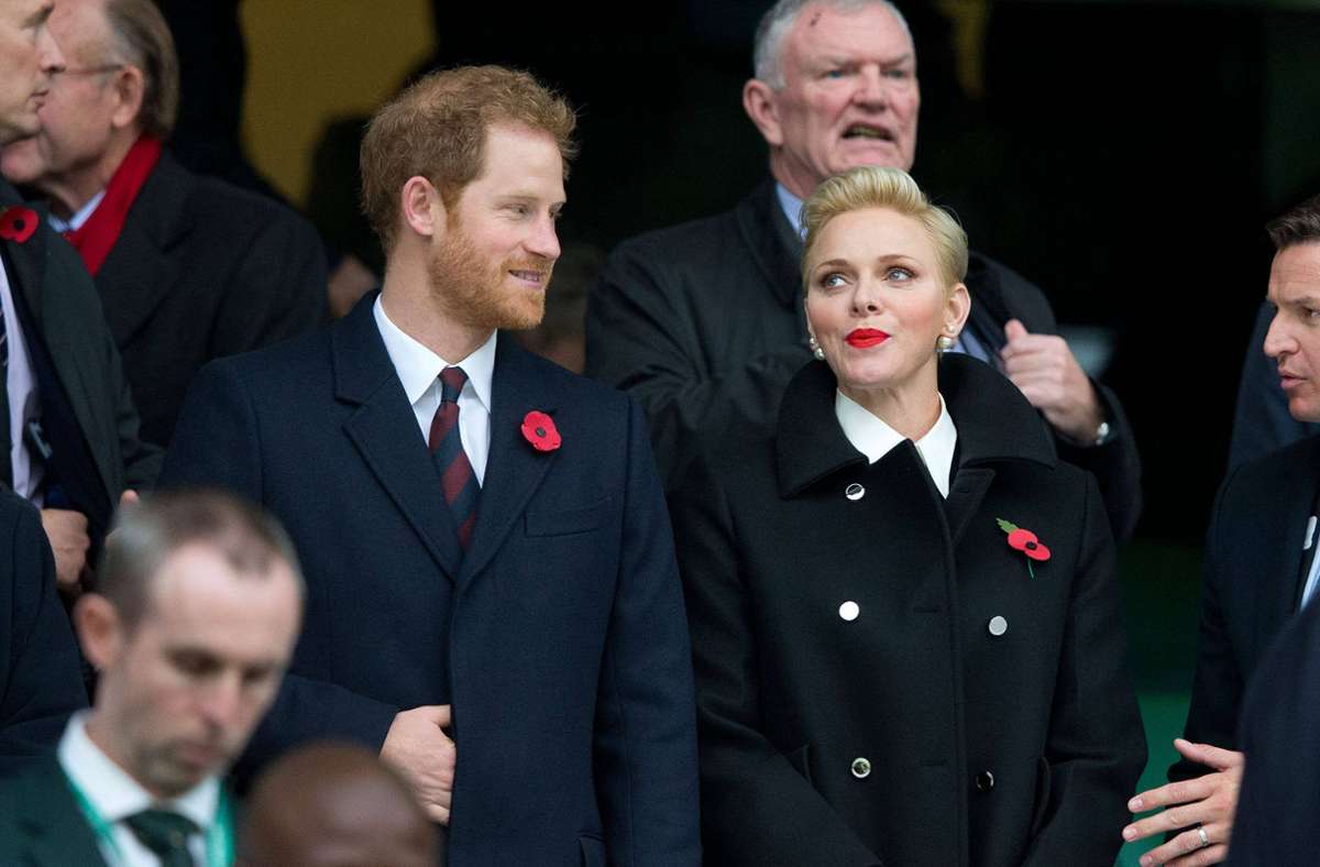 2016: Blonder Kurzhaarschnitt mit signalrotem Lippenstift – Fürstin Charlène trifft bei einem Rugby-Match Prinz Harry.