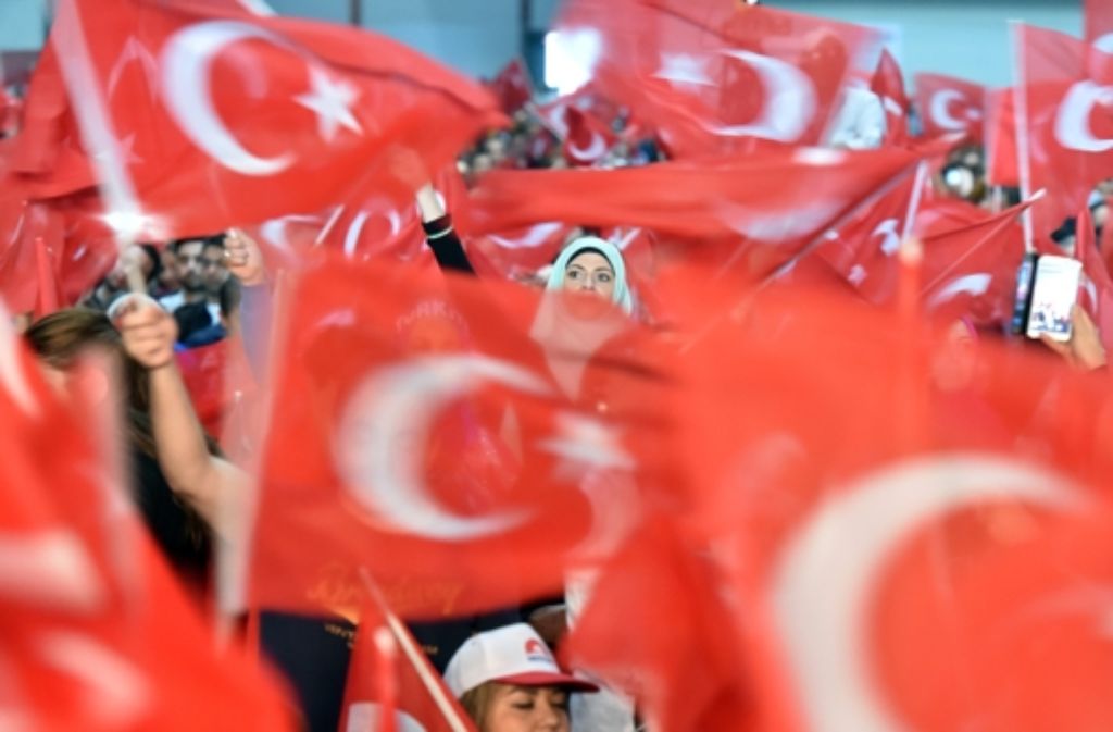 In einer Halle der Neuen Messe Karlsruhe versammeln sich am 10. Mai Anhänger des türkischen Staatspräsidenten Recep Tayyip Erdogan und schwenken dabei türkische Flaggen.