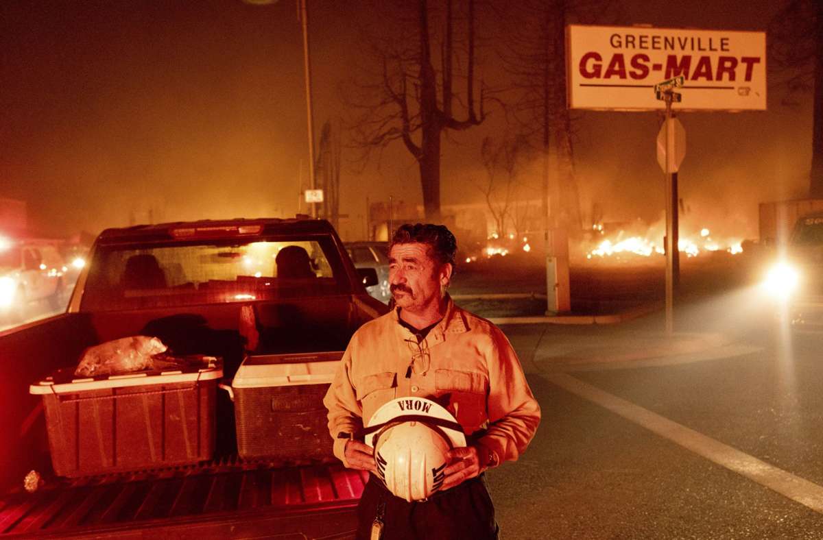 Battalion Chef Sergio Mora blickt auf das Feuer der Waldbrände des sogenannten Dixie-Feuers in der Gemeinde Greenville in Plumas County. Das Feuer zerstörte mehrere historische Gebäude und Dutzende von Häusern im Zentrum von Greenville.