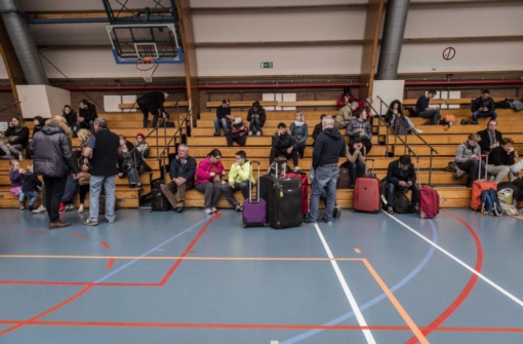 Einige der Reisenden halten sich in einer Sporthalle auf. Sie kommen nicht weiter, weil alle Flüge vom belgischen Flughafen gestrichen wurden und auch ein Großteil des Fernverkehrs mit dem Zug eingestellt wurde.