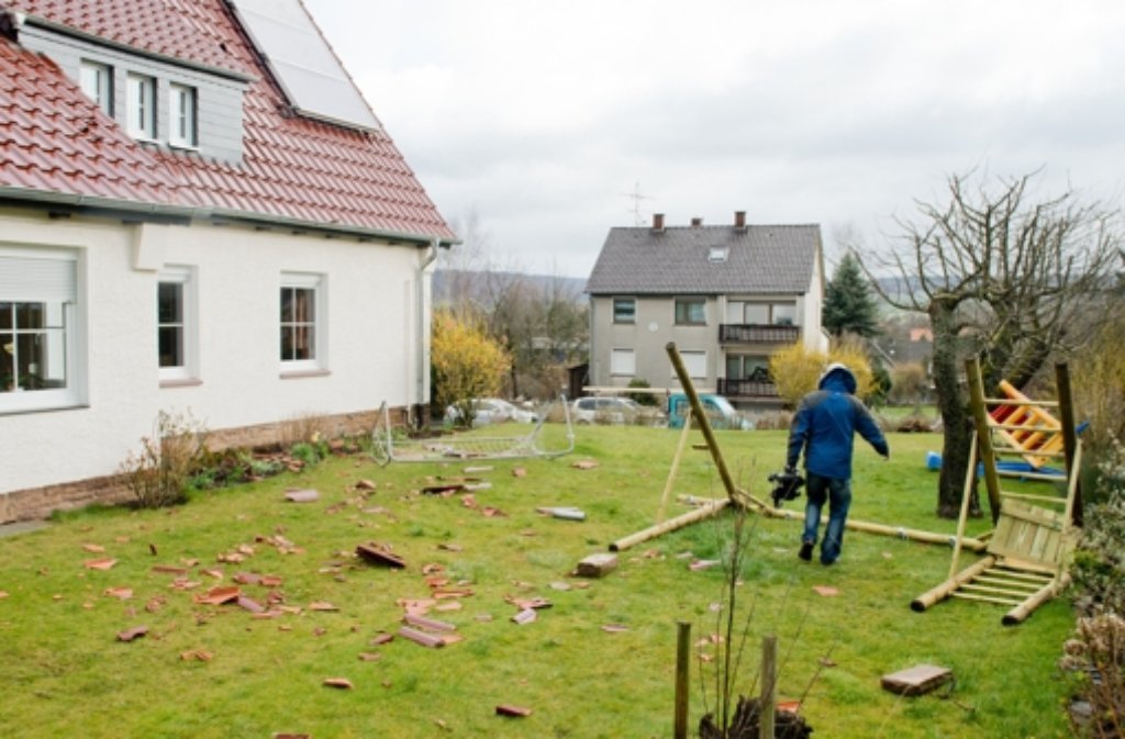 Dachziegel und umgestürzte Gartenmöbel liegen im Garten eines Einfamilienhauses in Coppenbrügge im Landkreis Hameln (Niedersachsen).
