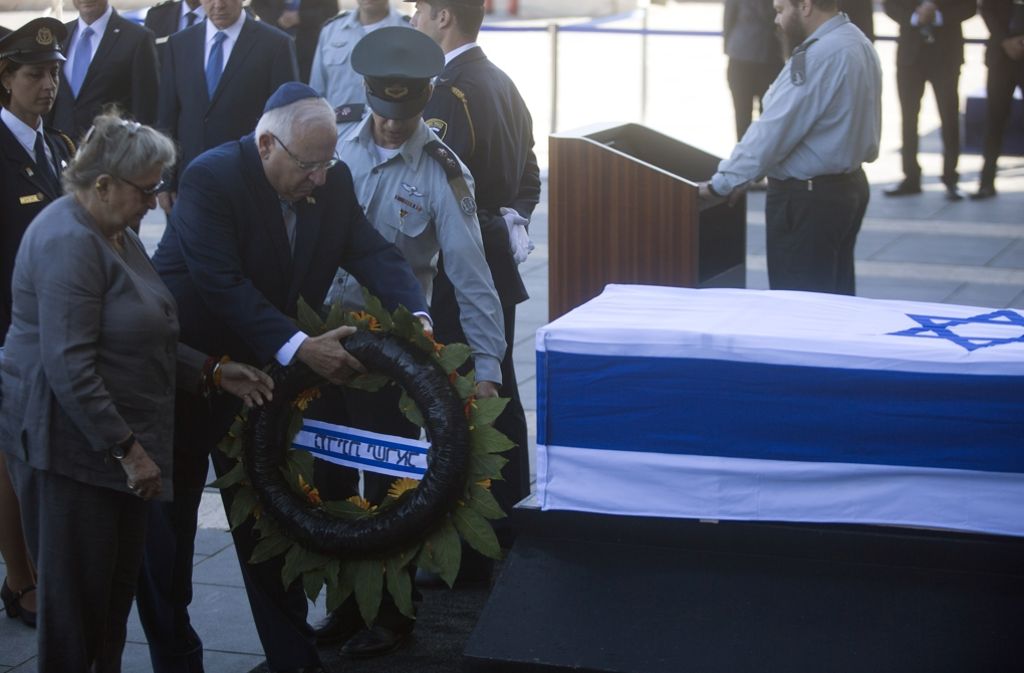 Der israelische Präsident Reuven Rivlin und seine Frau legen einen Kranz nieder.