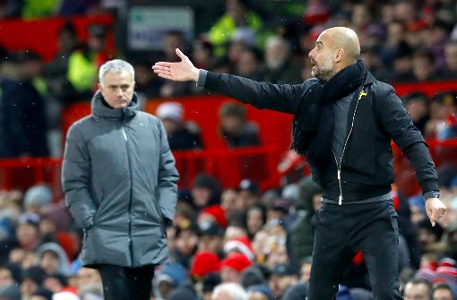 Manchester Citys Trainer Pep Guardiola (rechts) gestikuliert am Spielfeldrand. Links steht Manchester Uniteds Trainer Jose Mourinho. Foto: dpa