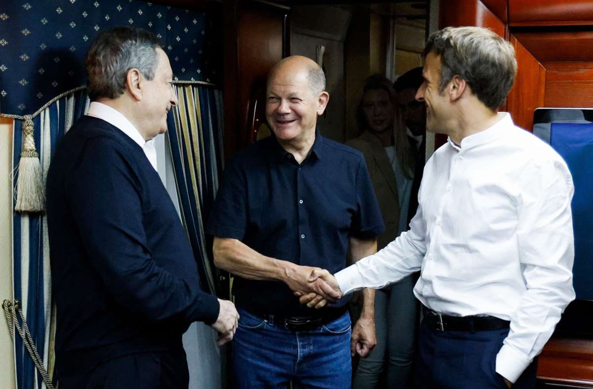 Mario Draghi (l.), Olaf Scholz (Mitte) und Emmanuel Macron begrüßen sich im Zug auf ihrer Reise nach Kiew.