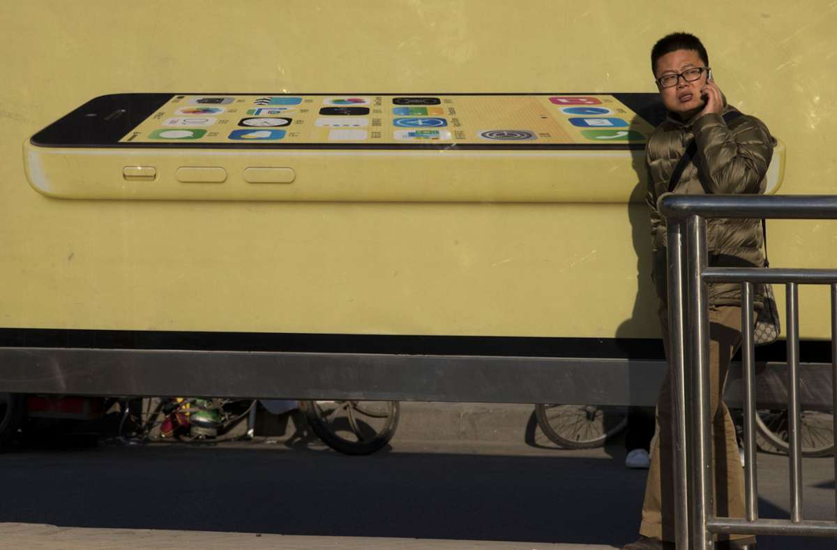 Passant in Peking vor einer iPhone-Reklame: Stimmt, telefonieren kann man mit den Dingern ja auch.