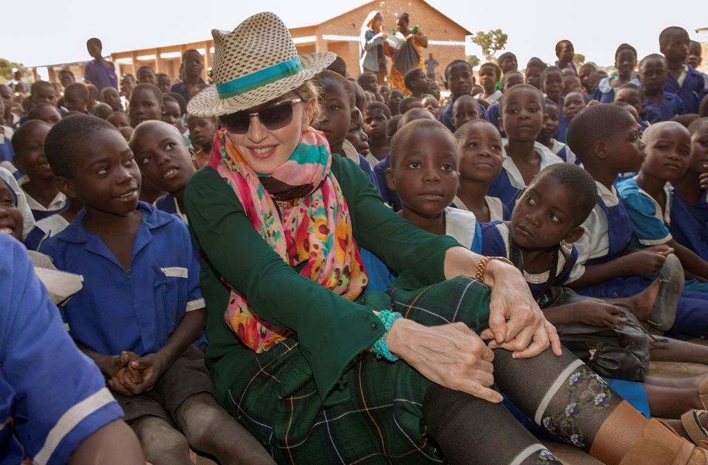 Die US-Sängerin engagiert sich mit ihrer Stiftung „Raising Malawi“ in dem südostafrikanischen Land und investierte nach eigenen Angaben Millionen von Dollar in die Betreuung von Waisenkindern und ins Bildungswesen. Auf dem Foto sitzt sie inmitten von malawischen Grundschülern.