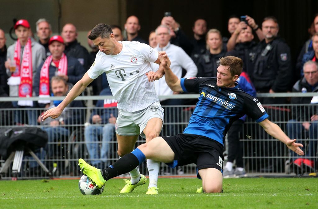 Auch Paderborns Luca Kilian (re./gegen Robert Lewandowski) trägt das Virus in sich. Er ist der erste Profi der Bundesliga, der positiv auf Corona getestet wurde. Nach zwei Tagen mit Fieber und Schüttelfrost geht es ihm inzwischen wieder besser.