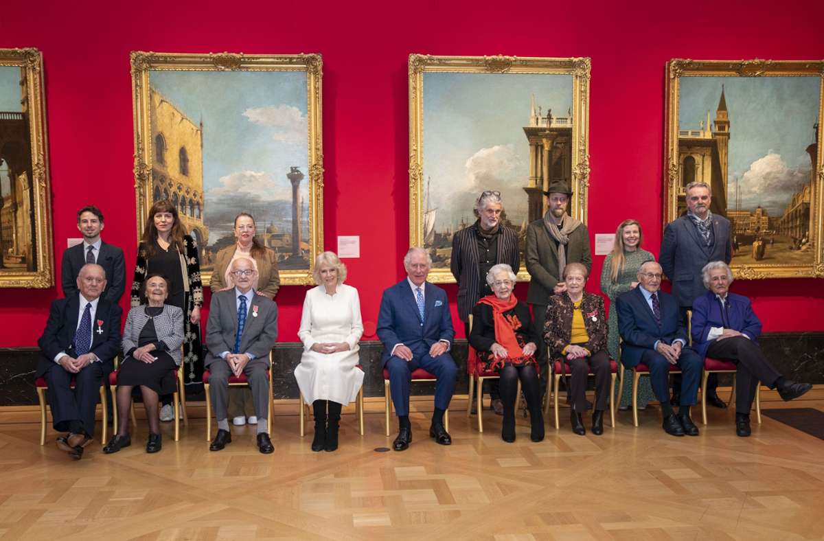 Die Künstlerinnen und Künstler mit den Überlebenden, die sie porträtierten. In der Mitte Charles und Camilla.