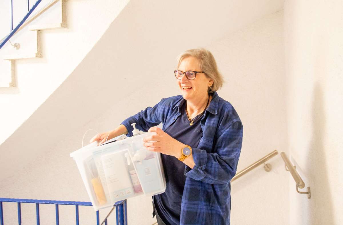Hauptamtsleiterin Karin Grund trägt eine Kiste mit Zubehör die Treppe im Interimsrathaus hoch.
