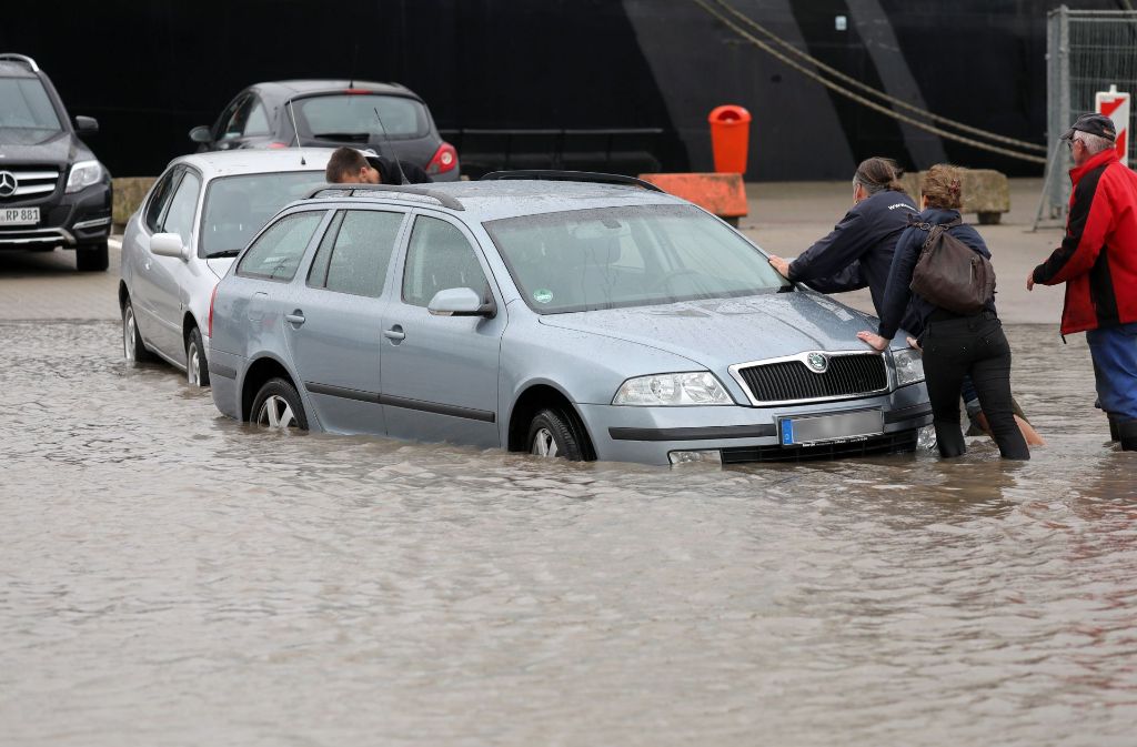 Auf einem Parkplatz im Stadthafen von Rostock standen nach stundenlangem Dauerregen Fahrzeuge im Wasser.