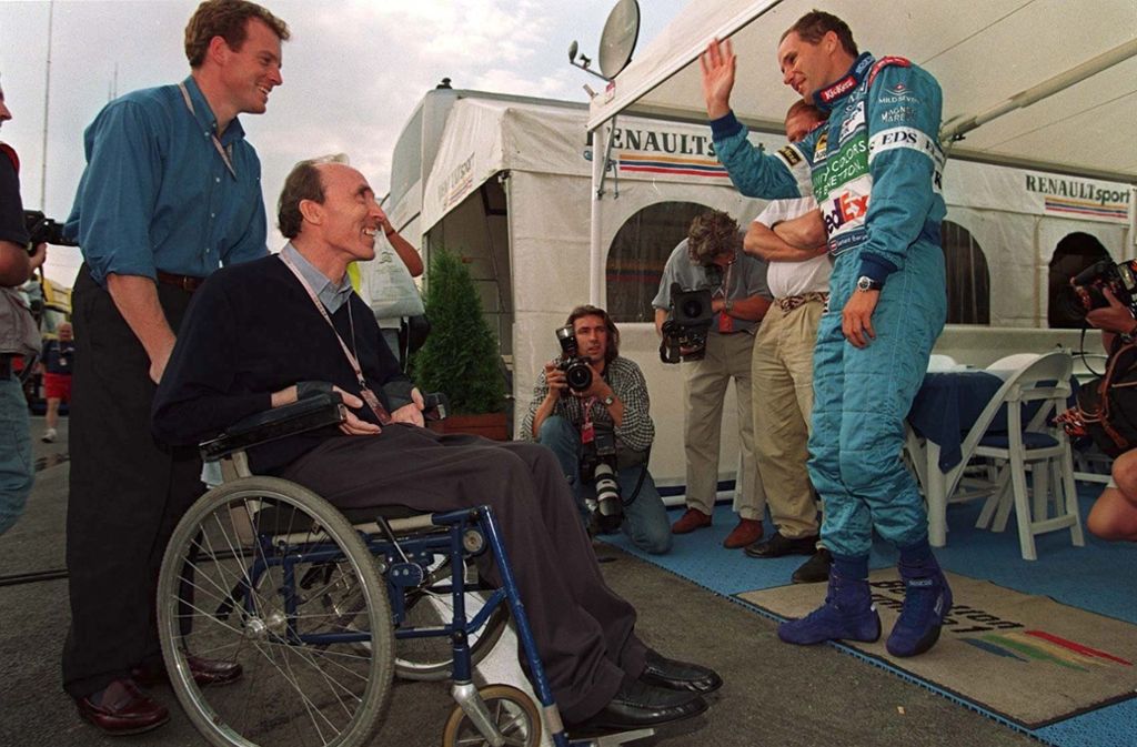 Ungarn-Grand-Prix 1997: Gerhard Berger begrüßt Frank Williams auf seine charmante österreichische Art. Dem Briten gefällt das.