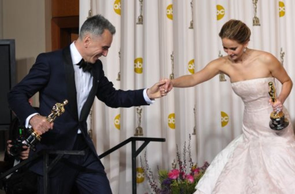 Die ausgezeichneten Daniel Day-Lewis reicht Jennifer Lawrence die Hand.