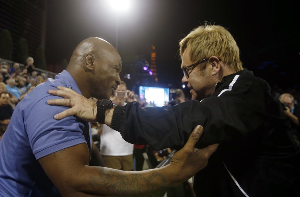 Gastgeber Elton John grüßt einen prominenten Gast des Turniers: den Boxer Mike Tyson.