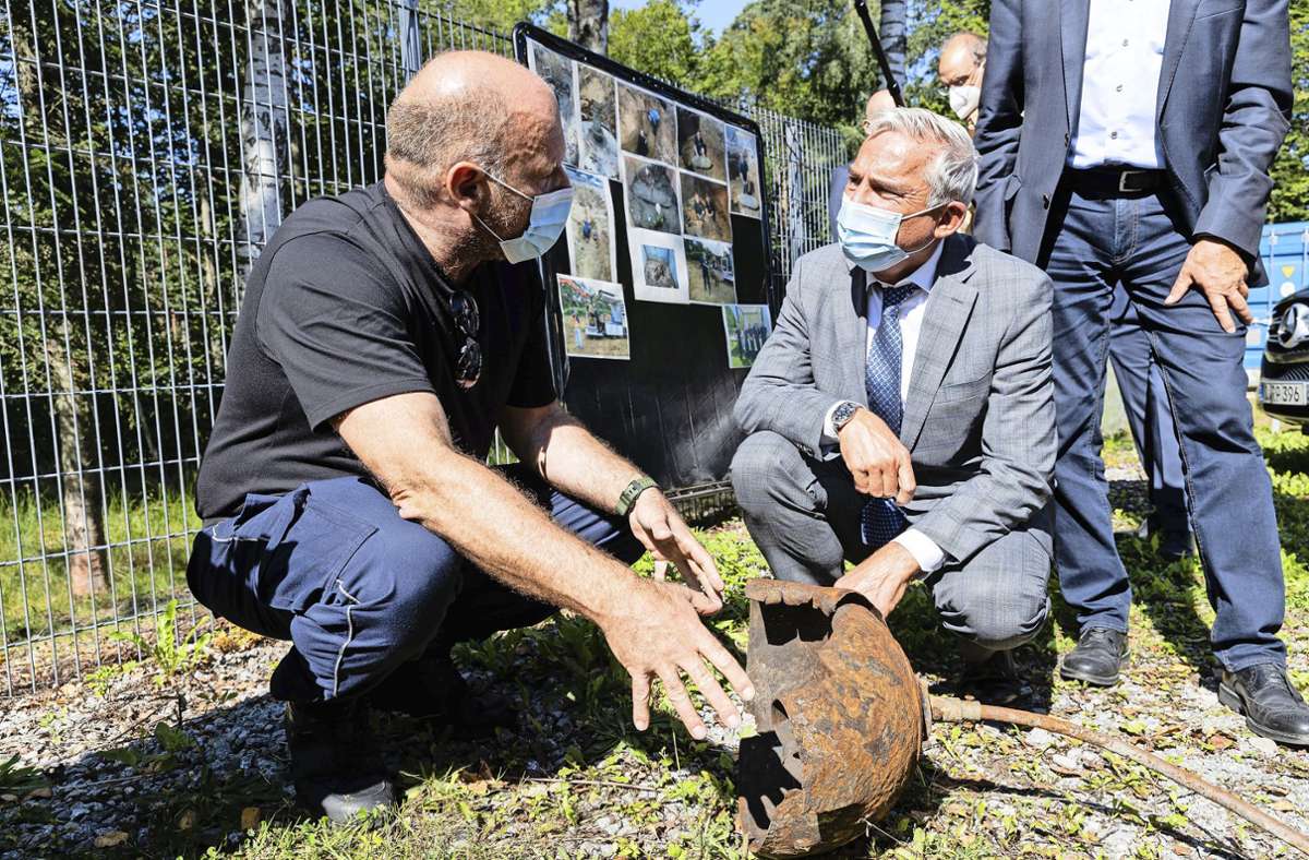Innenminister Strobl lässt sich von Spezialist Christoph Rottner den Rest einer in Mannheim entschärften Mine zeigen.