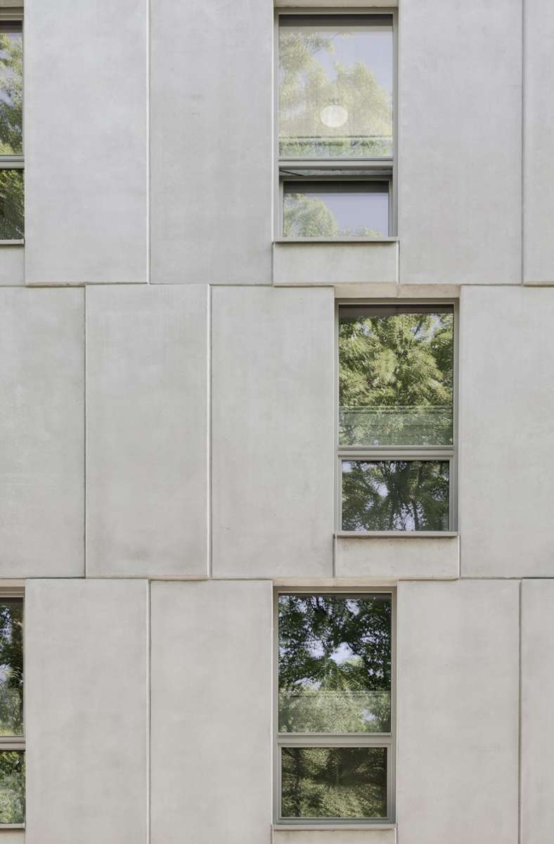 Die kerngedämmten Beton-Halbfertigteile für die tragenden Außenwände stammen aus dem Industriebau; die Architekten lassen die Fassadenteile regelmäßig minimal vor- und zurückspringen; so entsteht eine raffinierte Gliederung.