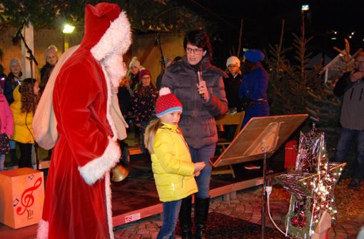 Hanna knipst den „Sternenhimmel“ an bei der Eröffnung des Weihnachtsmarkts durch Oberbürgermeisterin Gabriele Zull. Foto: Claudia Bell