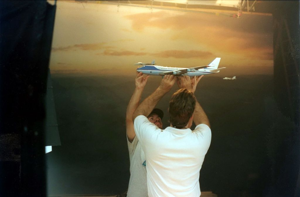 Ein Modell der Airforce One wird an Angelschnüren vor einem Foto-Hintergrund aufgehängt.
