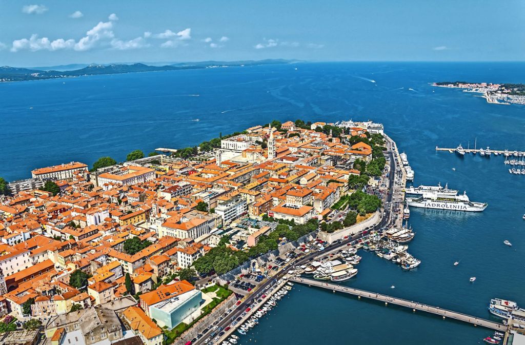 Zadar statt Dubrovnik: Die Hafenstadt Zadar, 350 Kilometer nördlich von Dubrovnik ebenfalls direkt an der Adria gelegen, war eine venezianische Seefestung und hat daher vieles, was auch in Dubrovnik verzaubert: historisches Flair, einen großen Hafen, vier mächtige Stadttore und eine Stadtmauer. Seit der Renaissance ist der Volksplatz, der Narodni trg, in der Mitte der Stadt auch der Mittelpunkt des Lebens. Hier entfaltet sich zu jeder Tageszeit eine rege Geschäftigkeit, die man wunderbar von einem der vielen Straßencafés aus beobachten kann. .  .