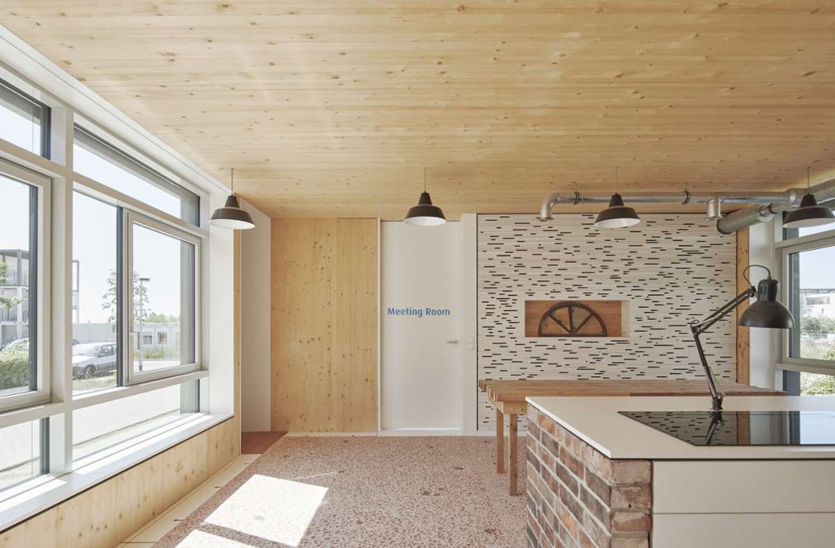 Der offene Wohn-, Küchen- und Essbereich im Erdgeschoss erhielt als Bodenbelag – über einer Dämmschüttung aus gebundenem Schaumglasgranulat – einen Guss-Terrazzo, der mit Ziegelsplitt und eingestreuten rötlichen Ziegelsteinfragmenten ein ansprechendes Mosaik erzeugt.