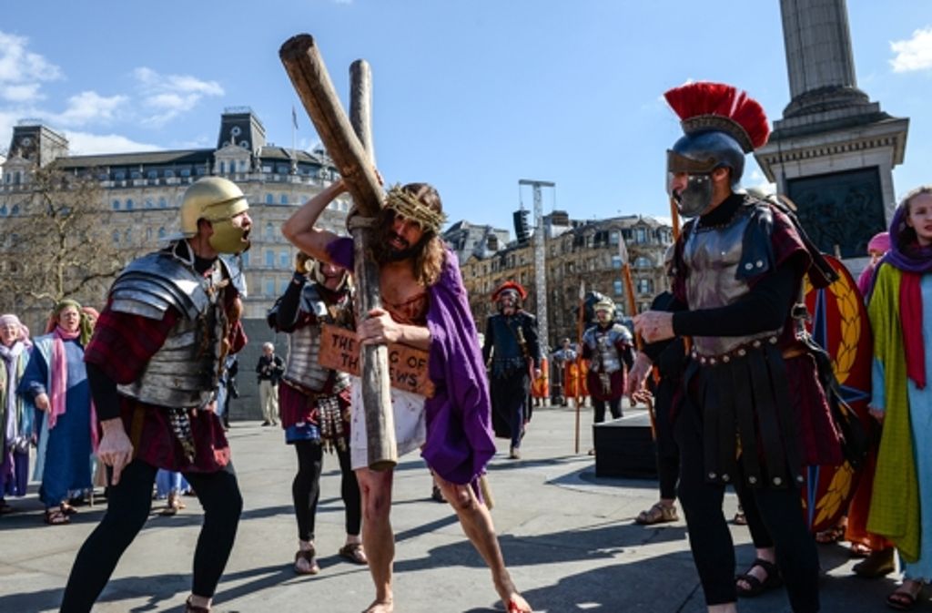 In London trägt der Schauspieler James Burke-Dunsmore das Kreuz als Jesus während der Prozession zu Karfreitag am Trafalgar Square.