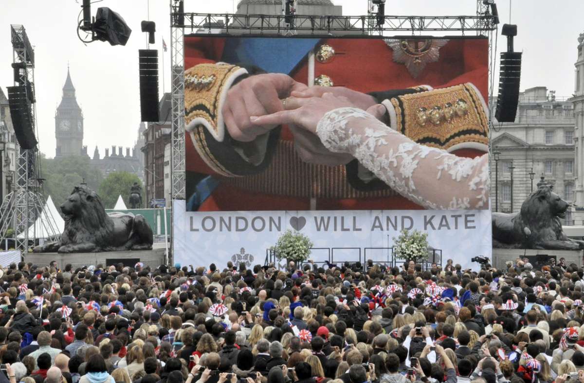 Die Menge vor den Großbildleinwänden an Londons Hotspots rast, als William seiner Kate den Ring ansteckt.