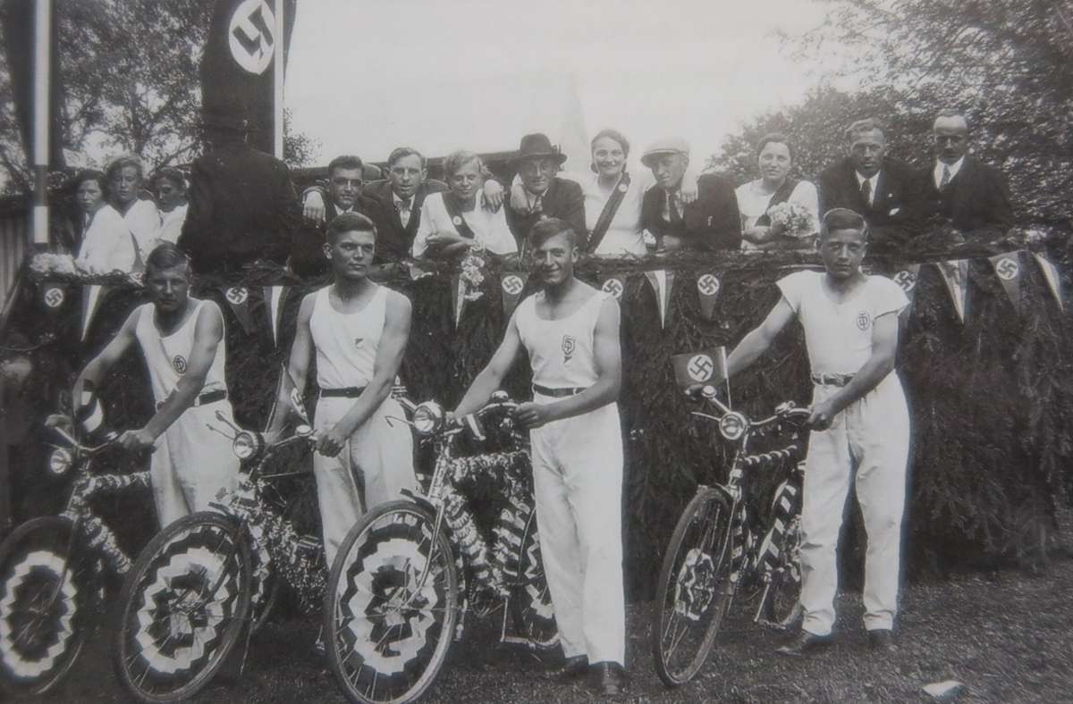 Radfahrer vor dem „Ehrenwagen“, auf dem 1937 die „ältesten und verdientesten Mitglieder“ des Turn- und Sportvereins bei einem Festzug gefahren wurden
