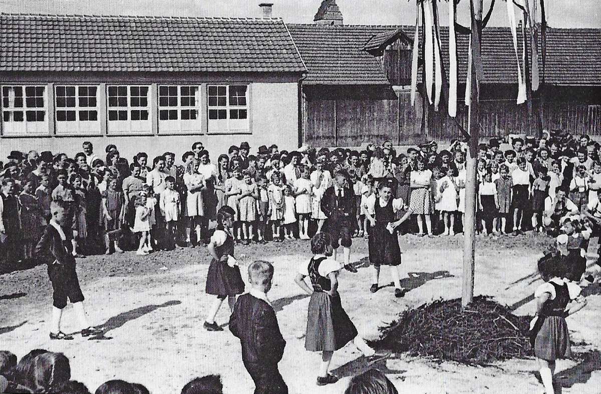 Kinder in Trachten tanzen 1950 um den ersten Maibaum der Egerländer Gmoi in Wendlingen.