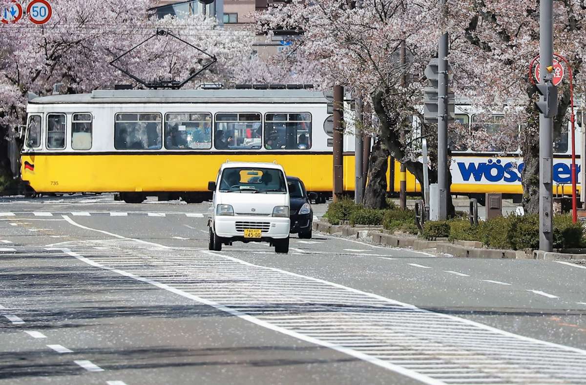 Eine Stuttgarter Straßenbahn fährt durch das frühlingshafte Fukui in Japan.