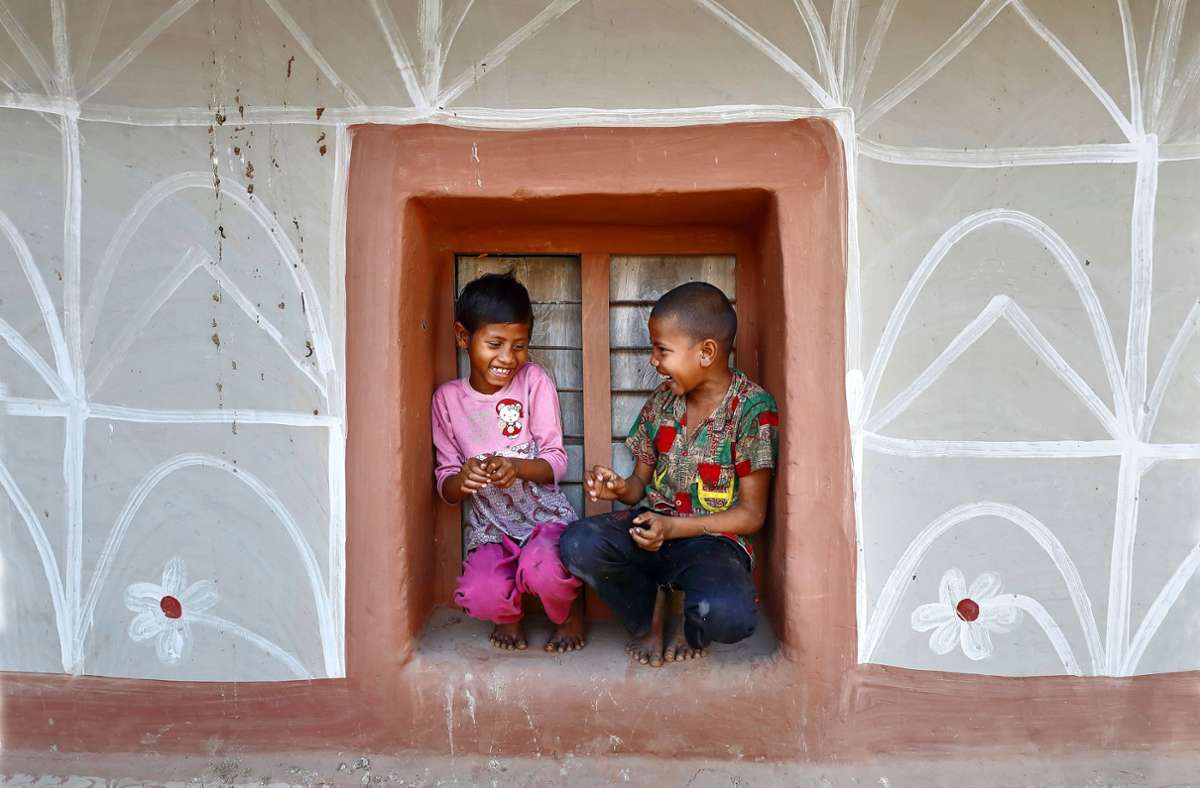 Angehörige der Volksgruppe der Santal bemalen häufig ihre Häuser mit floralen Ornamenten. Den Kindern bietet das Lehmhaus Schutz beim Spiel. Foto: Pern Images/Noor Ahmed Gelal