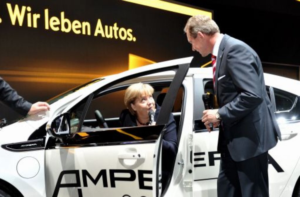 Auf der Ausstellungsfläche der Rüsselsheimer probiert die Kanzlerin den Sitzkomfort in einem Opel-Ampera und plaudert mit dem Vorstandsvorsitzenden der Adam Opel AG, Karl-Friedrich Stracke.