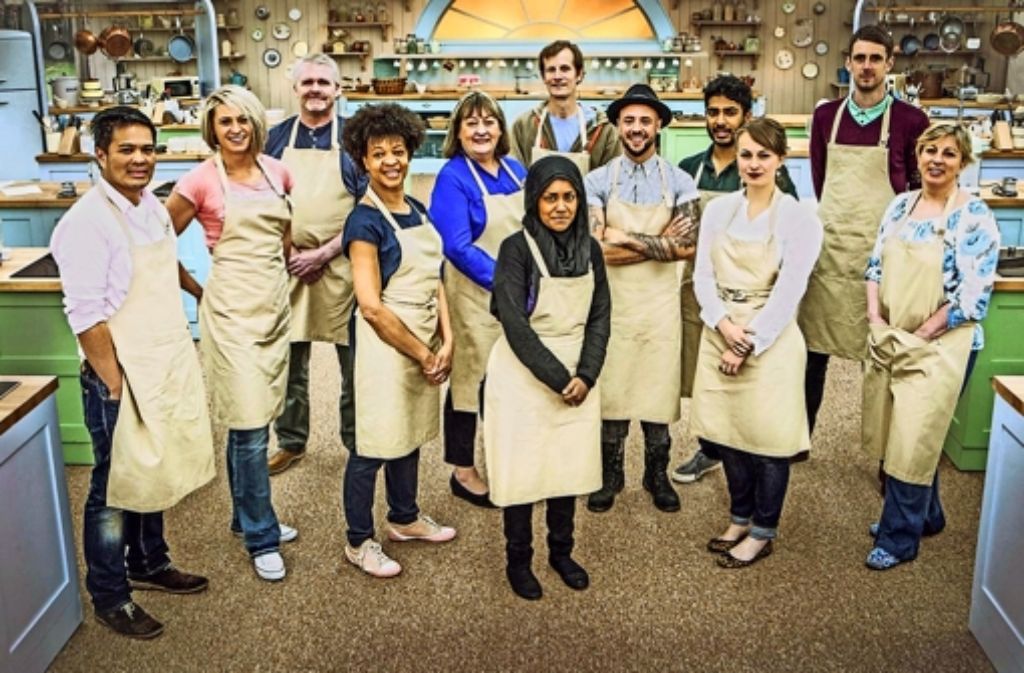 Nadiya Jamir (Mitte) posiert mit ihren elf Konkurrenten  für die beliebte britische Backshow „The Great British Bake Off“. Foto: BBC