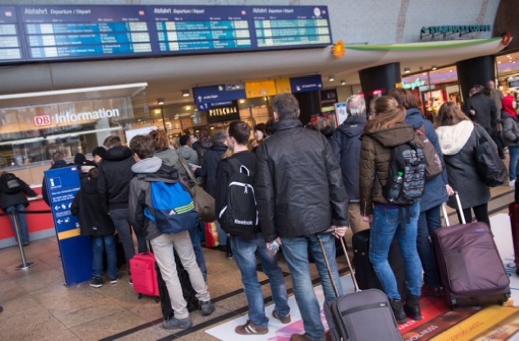 Reisende stehen am Hauptbahnhof in Köln (Nordrhein-Westfalen) an einem Informationsschalter der Deutschen Bahn.