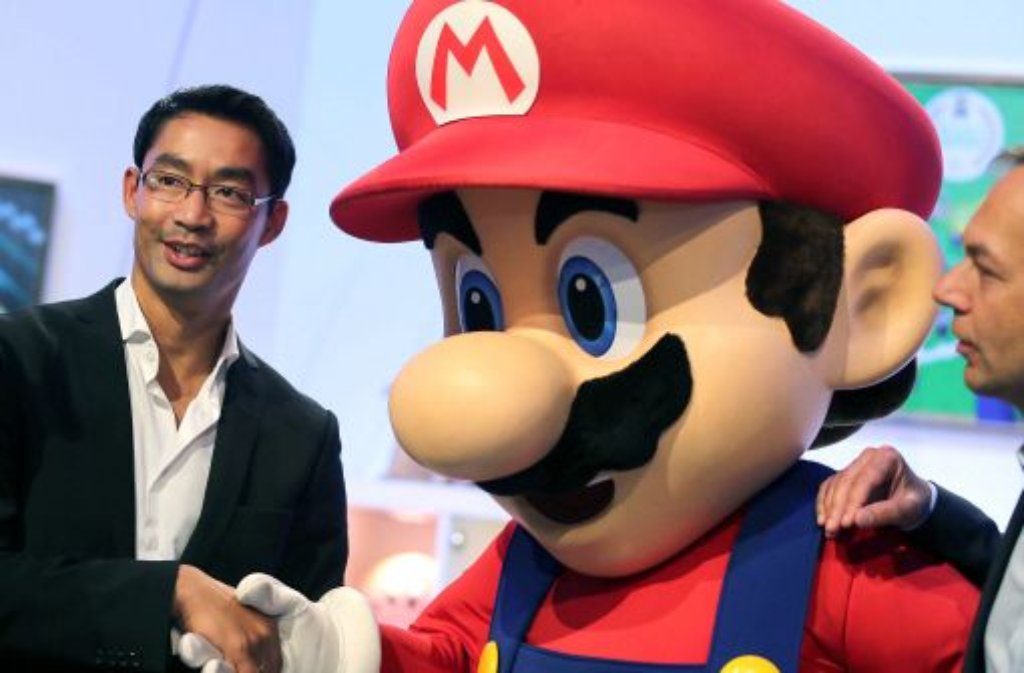 Bundeswirtschaftsminister Philipp Rösler wird auf der Gamescom vom Nintendo-Helden Supermario begrüßt.
