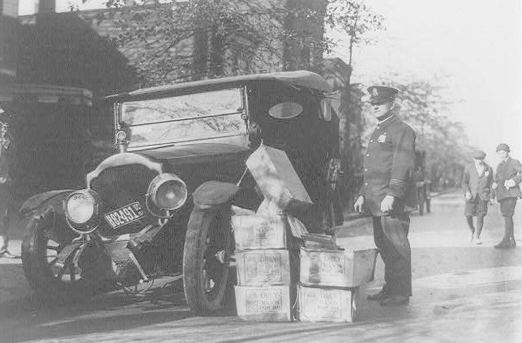 Ein Polizist 1922 mit einem beschlagnahmten Auto, in dem Alkohol transportiert wurde.