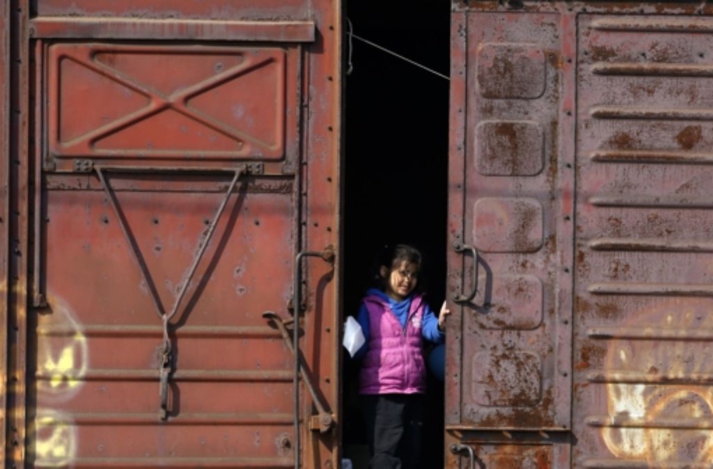 Ein Flüchtlingsmädchen in Idomeni schaut aus einem Güterwaggon heraus.
