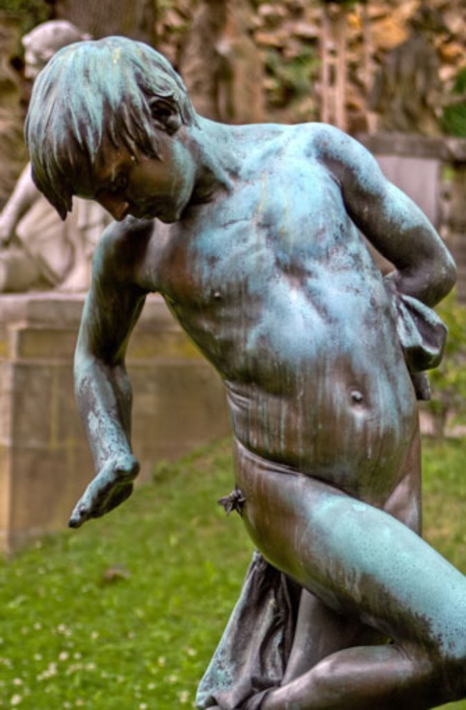 ... das "Muckenbüble" von Wilhelm Rösch, das mitten auf der Rasenfläche eine lästige Fliege von seiner Kehrseite verscheucht. Die Bronzestatue des Knaben stammt aus der Villa Berg.