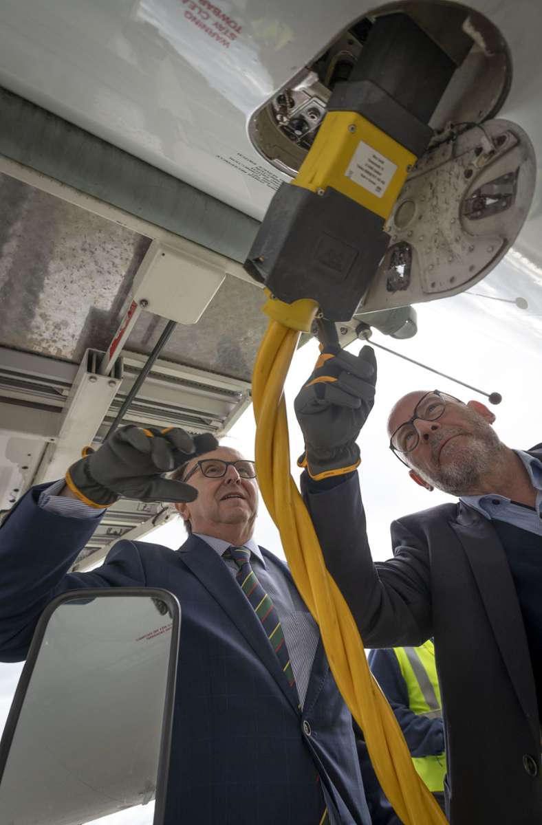 Flughafenchef Schoefer und Verkehrsminister Winfried Hermann lassen die Flugzeuge auf dem Vorfeld seit 2019 mit Strom vom Flughafen versorgen, damit die Turbinen nicht so lang laufen.