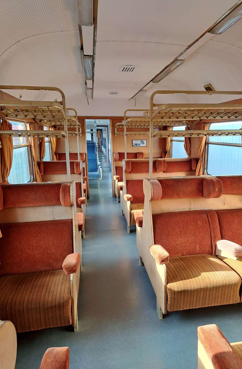Hier sieht man die erste Klasse in dem historischen Zug. Die Fahrgäste nehmen auf stoffgepolsterten Sitzen Platz.