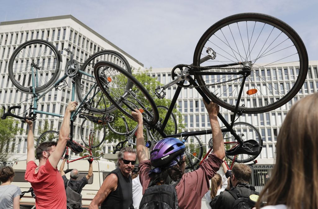 Menschen halten während einer Protest-Aktion Fahrräder in die Luft.